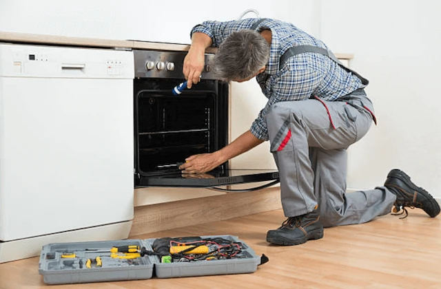 Technician inspecting the inside of an oven with a flashlight